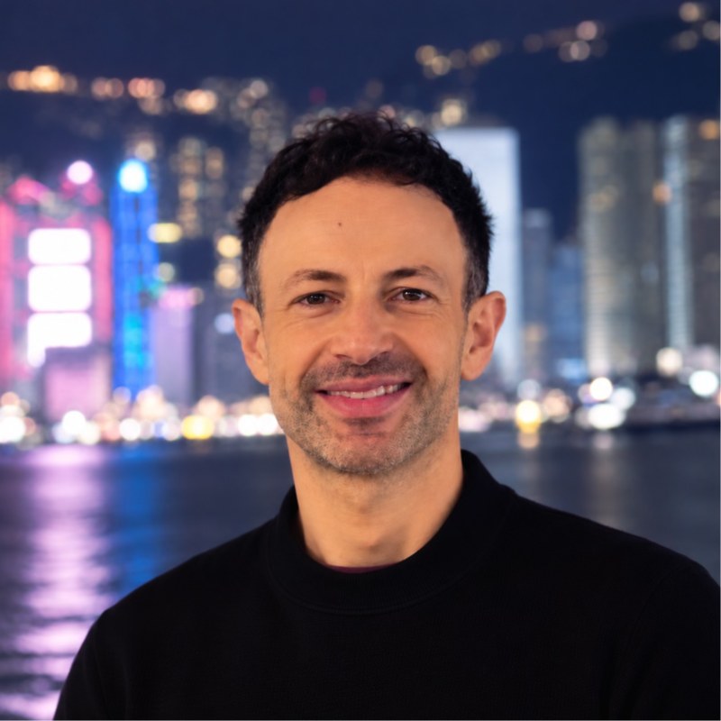 Luca Tarabini, smiling, in front of a city skyline at night